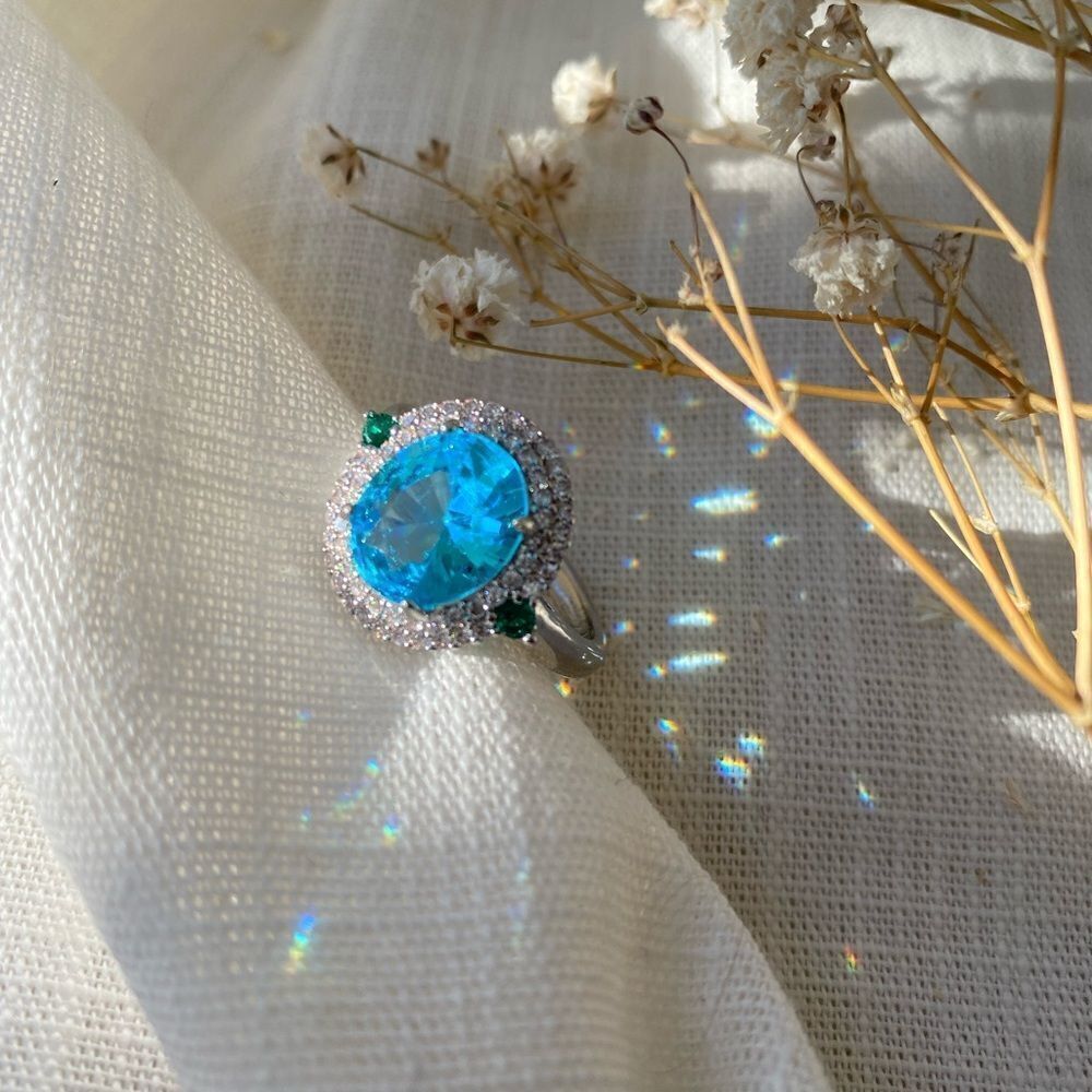 Oval cut blue zircon double halo ring w/ emerald green  accents on the sides